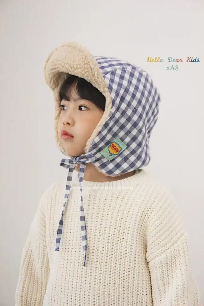 Kids winter hat with checkered pattern and cozy fleece lining, perfect for warmth and style.