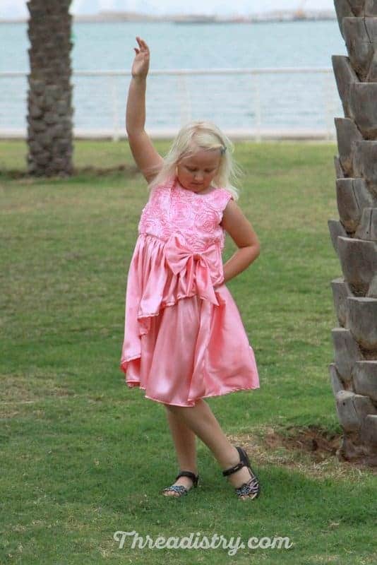 Little girl wearing the Poinsettia Party Dress by GYCT Designs