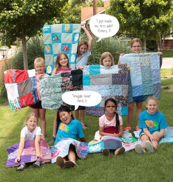Girls with the hand-sewn quilts they made