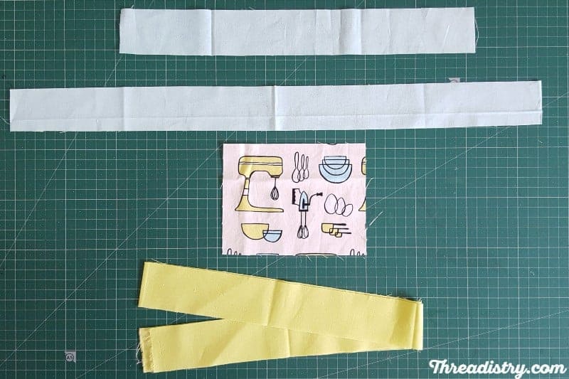 Fabric strips and centre square to make a log cabin quilt block.