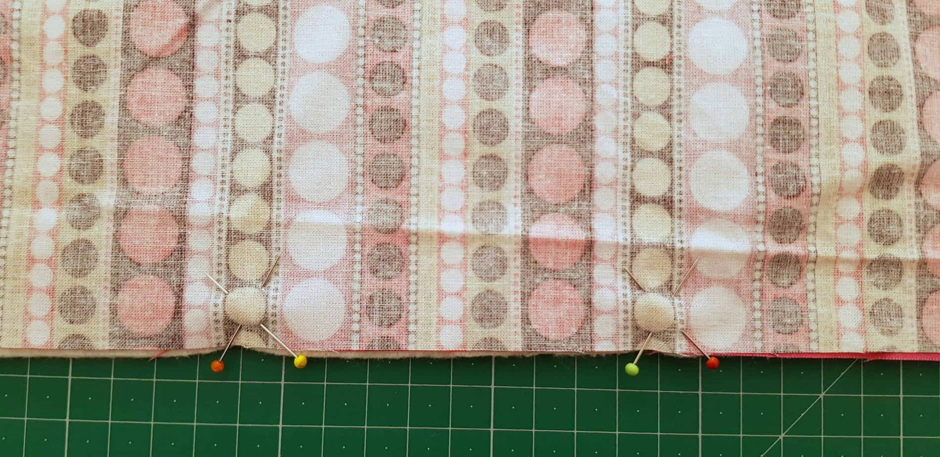 Pins pinned to edge of fabric to make a cross to mark the fabric opening.
