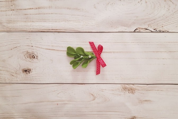 Completed DIY felt mistletoe hairclip with red ribbon bow