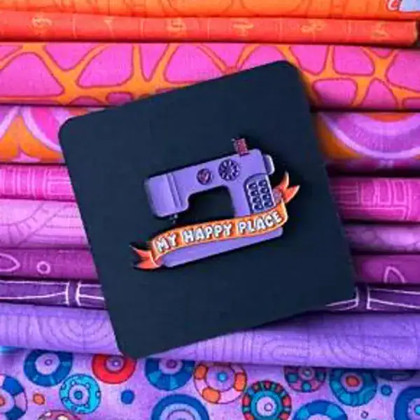 Colorful quilted fabric with embroidered camera and "My Happy Place" badge, showcasing creative handmade textile art.