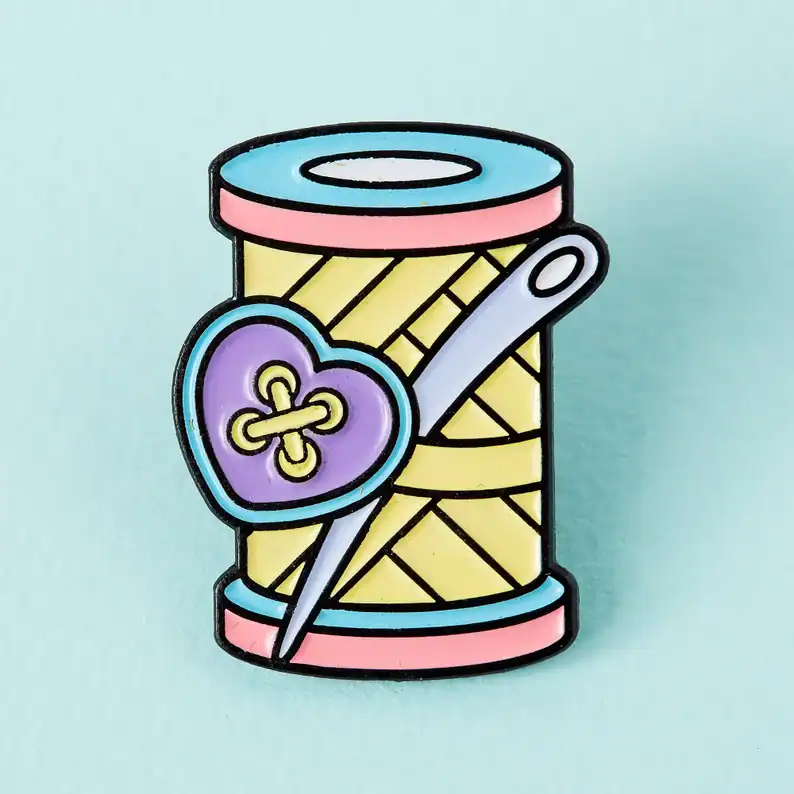 Spool of thread with heart-shaped needle craft pin, colorful sewing accessory, craft supplies, embroidery.