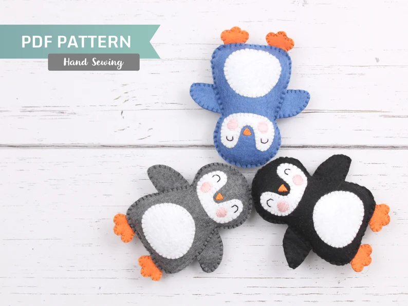 Three hand-sewn felt penguins