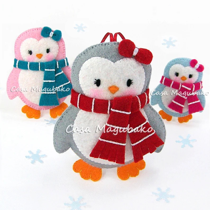 3 cute felt penguin ornaments with penguins wearing a scarf and a little bow.