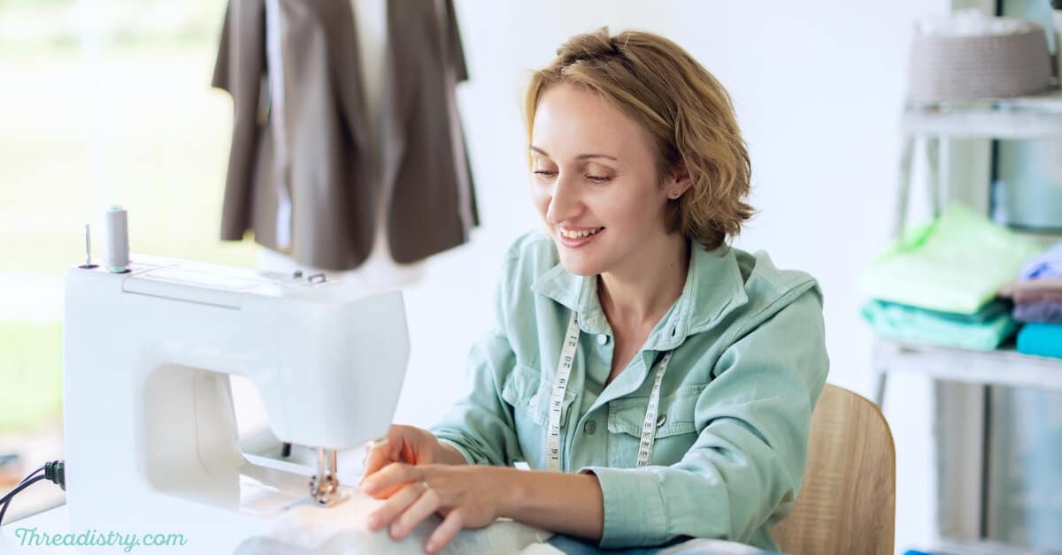 Professional dressmaker woman sews clothes on sewing machine at