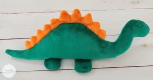 Flat dinosaur plush toy on white wooden table