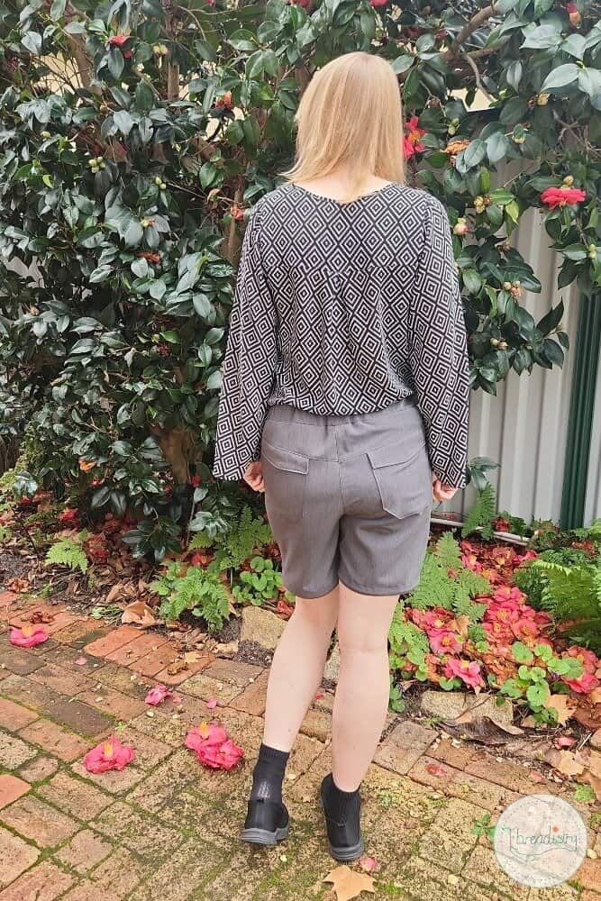 Comfortable casual outfit featuring a patterned long-sleeve top and tailored shorts for outdoor wear.