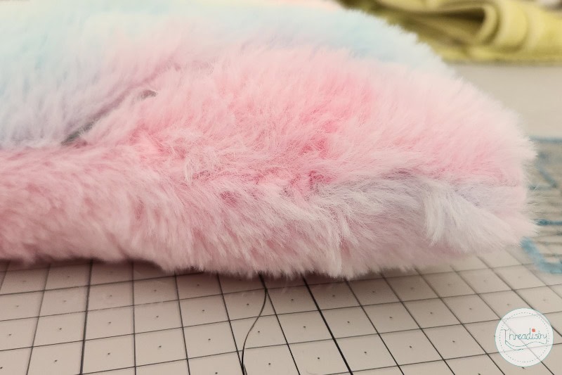 Soft pink plush faux fur fabric for crafting or sewing projects.