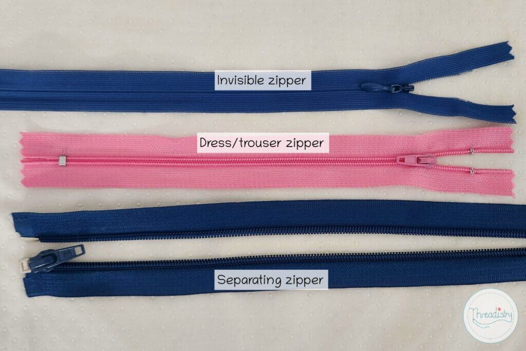 Blue invisible zipper, pink dress/trouser zipper, and blue separating zipper for clothing.