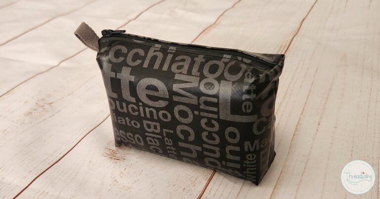 Black zipper pouch on a white wooden table