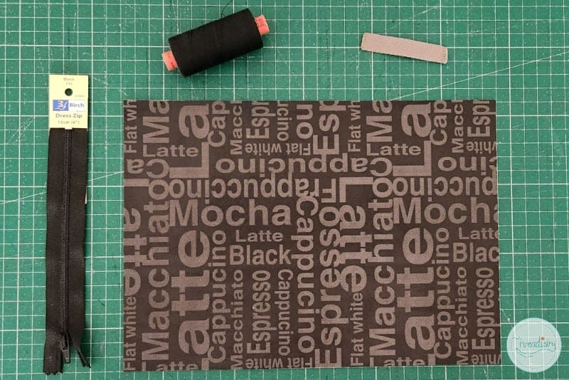 Soft fabric with coffee-themed print and zippers, ideal for creating custom accessories or crafts.