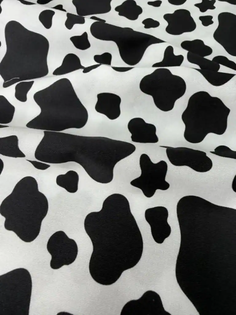 Black and white cow print fabric ideal for plush cow toys and sewing projects.
