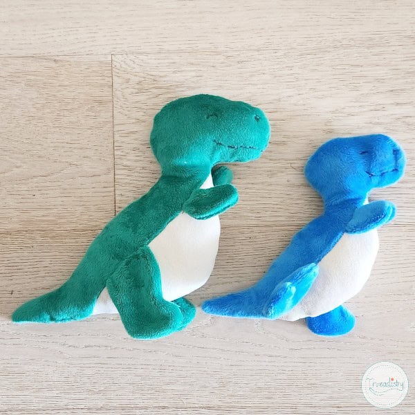 Soft plush dinosaur toys in green and blue, perfect for kids' play and cuddling.