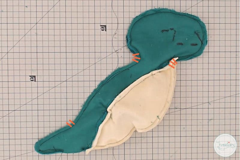 Cute fabric plush toy resembling a dinosaur or dragon.