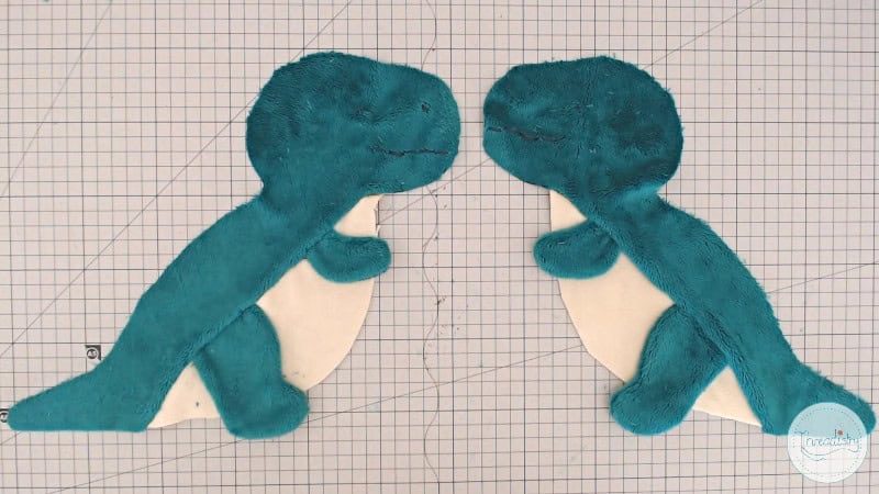 Adorable plush dinosaur toys in teal and cream colors, perfect for kids' toys or collectibles.