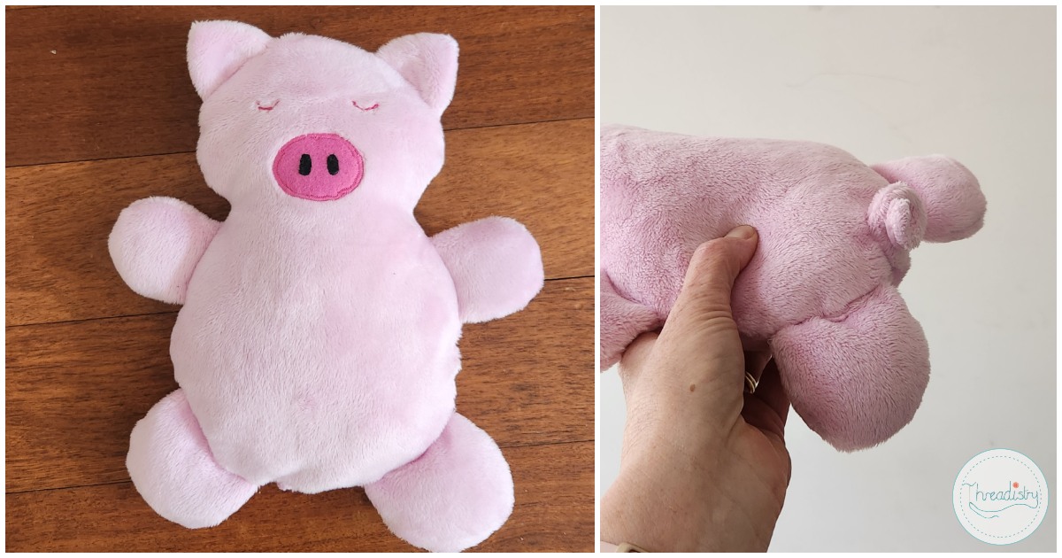 Soft pink pig plush toy with round body and small ears, ideal for children.